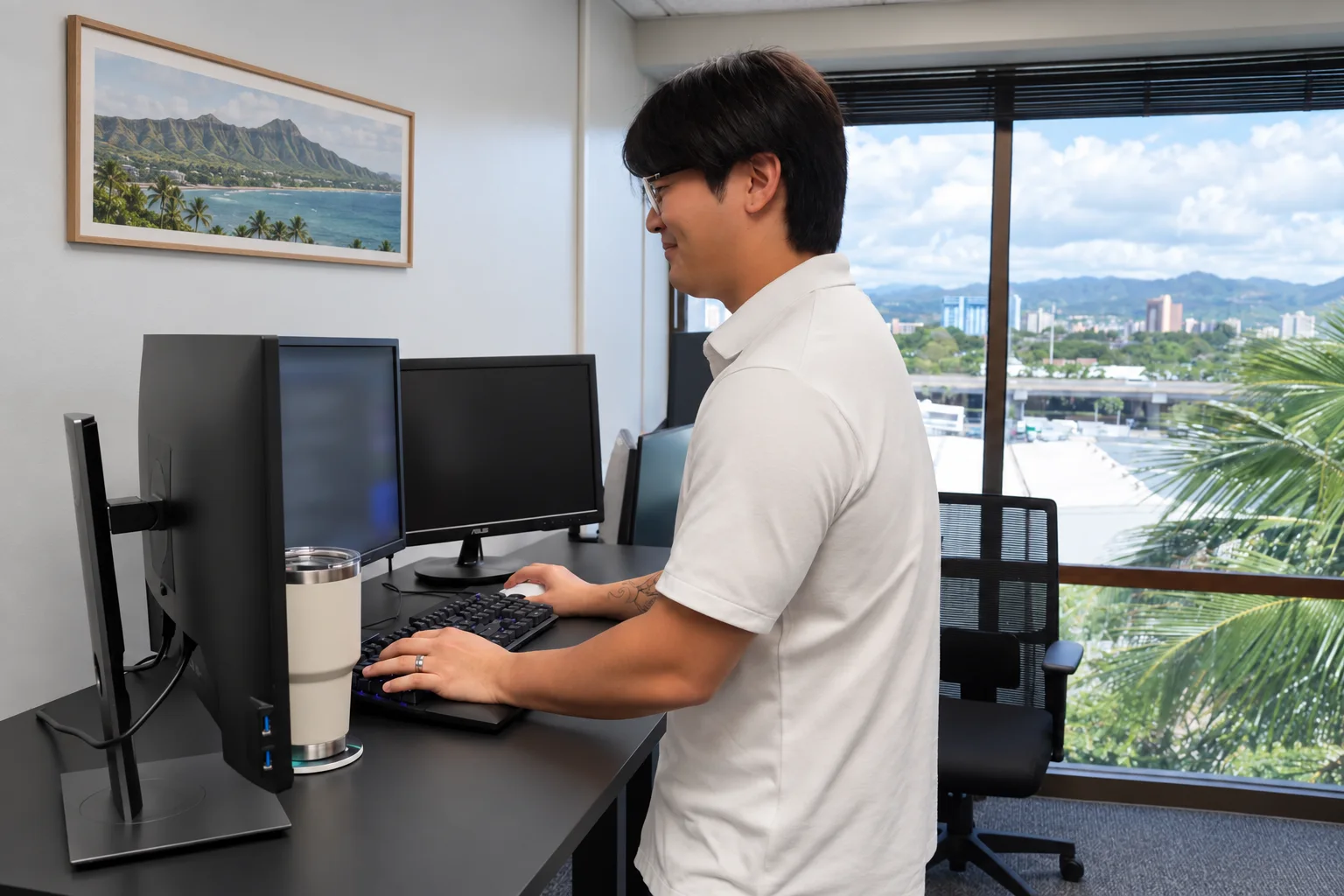 An Enlighten team member working at a standing desk in our Honolulu office.